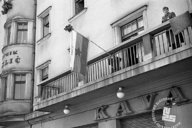 Izobešanje zastave XV. SNOUB (belokranjske brigade) na balkonu hotela Miklič nasproti ljubljanskega kolodvora. 9. maj 1945....