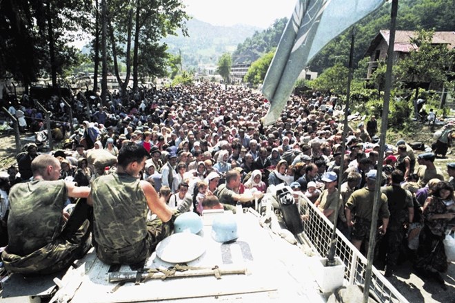 Nizozemski pripadniki mirovnih sil OZN sedijo na oklepniku v Potočarih na arhivski fotografiji iz julija 1995. Okoli so...