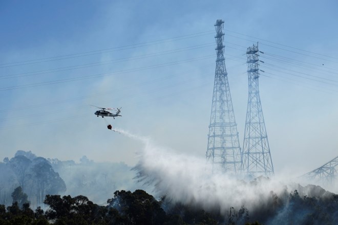 Pri gašenju se pomajo tudi s helikopterji.