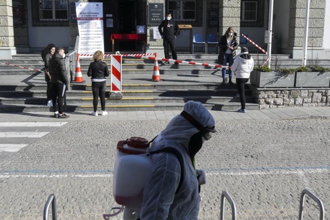 #fotogalerija Razkužujejo ograje, klopi, semaforje in kljuke po mestu