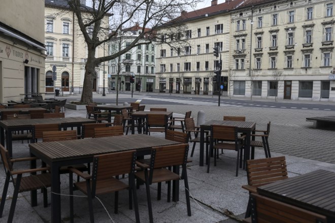 Prazne mize gostinskih lokalov v središču mesta.