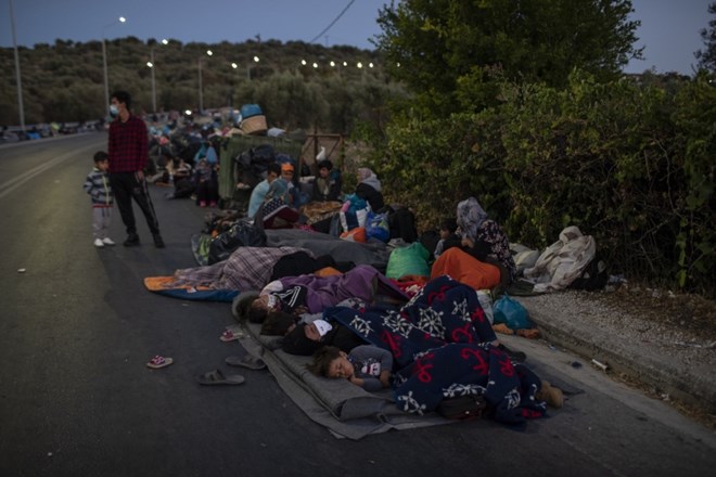 Migrants sleep on the road near the Moria refugee camp on the northeastern island of Lesbos, Greece, Thursday, Sept. 10,...