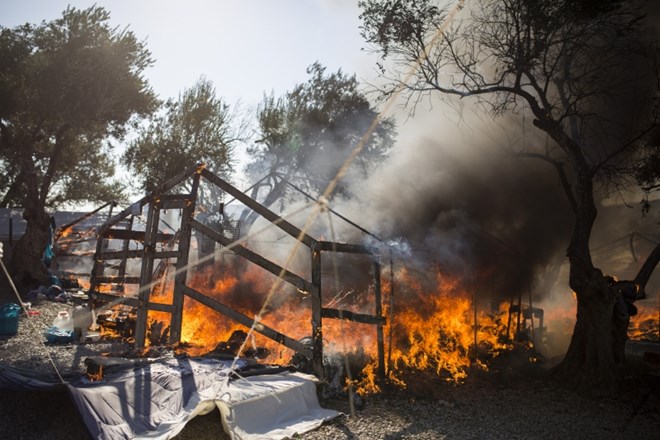 10 September 2020, Greece, Moria: Fire burns through the tents of the already scorched Moria refugee camp that was almost...