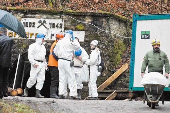 Posmrtni ostanki forenzično preiskanih žrtev, ki so jih našli v rovu in prvem jašku, ležijo v plastičnih  zabojih ob vhodu,...