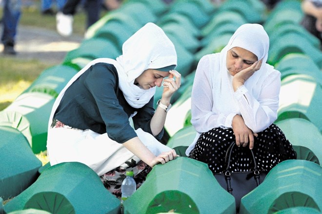 Žalujoči Bošnjakinji ob krsti s posmrtnimi ostanki v Srebrenici ubitega sorodnika med pogrebom 71 v zadnjem letu dni...