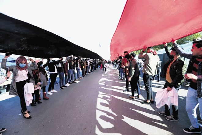 Udeleženci protivladnih protestov so v Bagdadu danes razvili velikansko iraško zastavo.