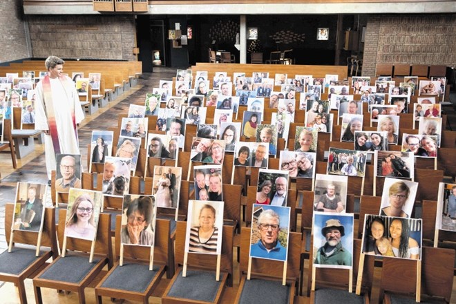 Pater Simon de Vries v spodnjesaškem Nordhornu je obkrožen s fotografijami vernikov, ki letos  ne morejo biti navzoči pri...